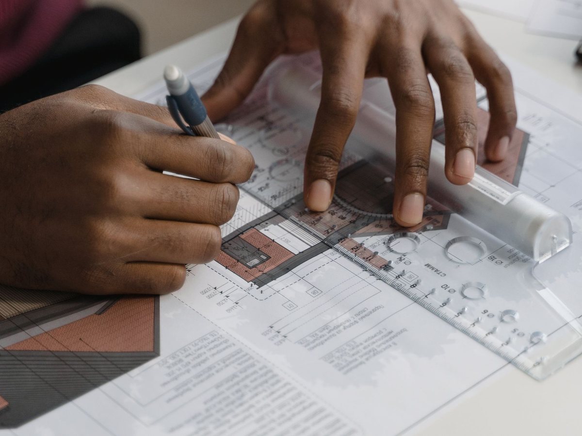 Hands drawing a custom blueprint with a ruler and pencil