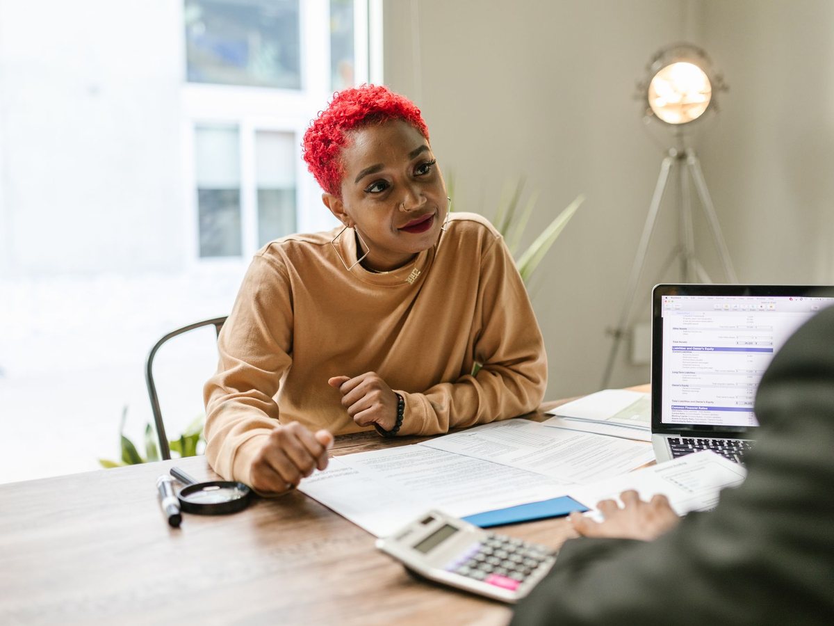 Advisor listening closely while a client reviews her financial documents